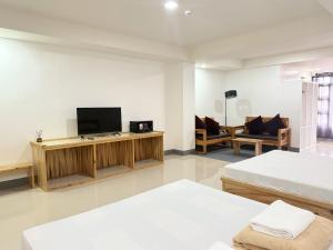 ein Wohnzimmer mit zwei Betten und einem Fernseher in der Unterkunft The Sagada Hotel in Sagada