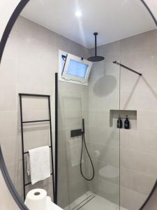 a bathroom with a shower with a window and a mirror at Diana's House - Nazaré in Nazaré +31 photos