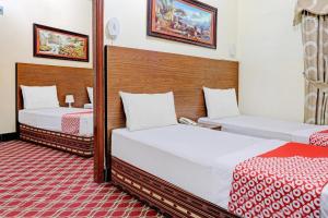 a hotel room with two beds and a mirror at Al Arraf Hotel in Dubai