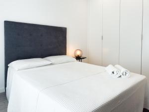 a white bed with two towels on top of it at Diana's House - Nazaré in Nazaré