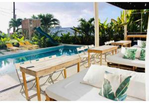 a pool with tables and chairs next to a swimming pool at Paradise Point Barbados in Christ Church