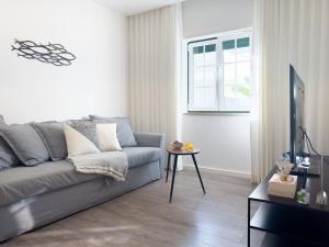a living room with a gray couch and a table at Diana's House - Nazaré in Nazaré
