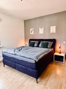 a bedroom with a large blue bed in a room at Pfalzliebe Ferienwohnung Emilia in Dahn