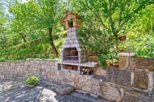 a stone wall with a brick oven in a garden at Casa Mira by Rent Istria in Pazin