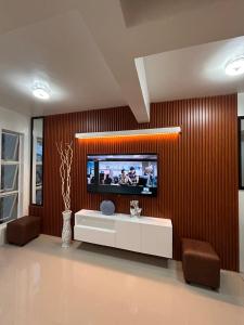 a living room with a television on a wall at 2-Storey Town House 2 Bedroom in Conel