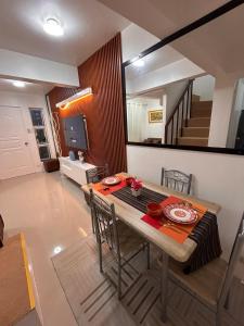 a dining room with a table with chairs and a mirror at 2-Storey Town House 2 Bedroom in Conel