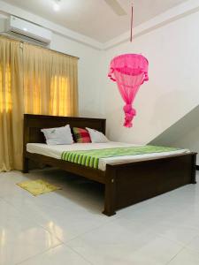 een slaapkamer met een bed met een roze ballon aan de muur bij New Mango Villa in Matara