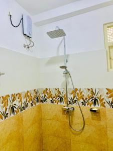 een douche in een badkamer met een muur bij New Mango Villa in Matara