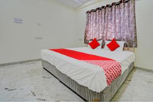 Un dormitorio con una cama grande con almohadas rojas. en Hotel O BlueBird Service Apartment, en Nagpur