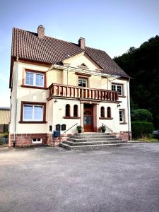 a large house with a staircase in front of it at Pfalzliebe Ferienwohnung Emilia in Dahn