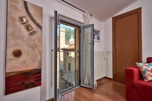 Zimmer mit einer Glasschiebetür und einer roten Couch in der Unterkunft La chiave di Volta in Como