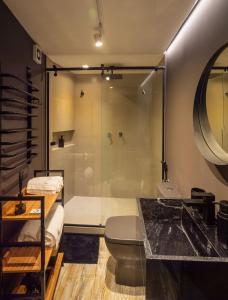 a bathroom with a shower and a toilet and a sink at Domo nas Alturas! Lareira, Hidro e Céu Estrelado in Rancho Queimado