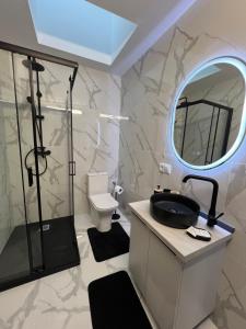 a bathroom with a sink and a shower and a mirror at Nesto Rooms in Sighetu Marmaţiei
