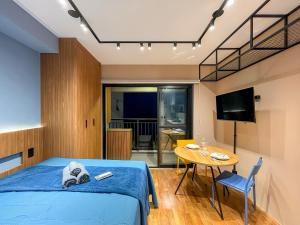 a bedroom with a bed and a table and a tv at Condomínio com piscina ao lado do Parque Buenos Aires in Sao Paulo