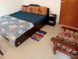 a bedroom with a bed and a table and a stool at Mamta Home Stay in Ayodhya