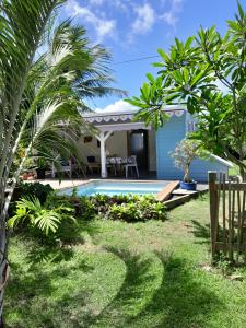 a villa with a swimming pool and palm trees at Ti kaz a Max in Saint-François