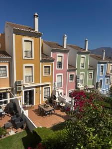 a row of colorful houses with a patio and tables at Casa Dos Palomas in Bahia de Casares