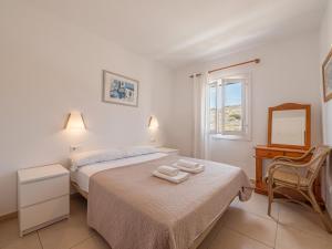 Un dormitorio con una cama con dos toallas encima. en Tramontana 115 P1, en Fornells