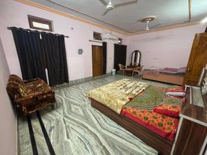 a bedroom with a bed and a chair in it at G K HAVELLi in Bikaner +25 photos