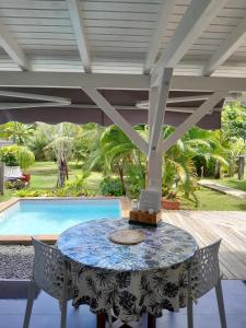 a patio with a table and chairs and a pool at Ti kaz a Max in Saint-François