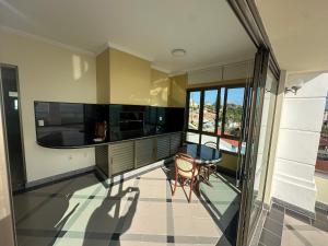 a kitchen with a table and a chair on a balcony at Golfinhos Apart Hotel in Florianópolis