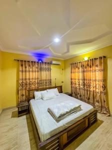 1 dormitorio con 1 cama grande y cortinas en Revolution Apartment Lemode Kobape abk, en Abeokuta