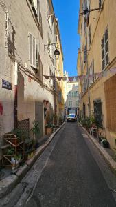an alley with a car driving down a street at Le panier à vos pieds in Marseille