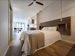 a bedroom with a large bed with a wooden headboard at Lhome Macarena in Seville