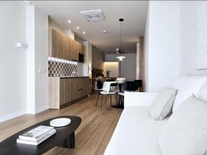 a living room with a white couch and a table at Lhome Macarena in Seville +9 photos