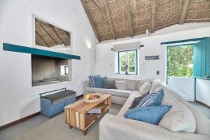 a living room with a couch and a table at Cape Creek Cottage, Luxury Coastal Getaway in Struisbaai