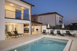 a house with a swimming pool in front of a house at Villa D&J in Vodnjan