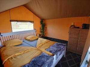 a bedroom with a bed in a room with a window at Safaritent 3 in Biddinghuizen