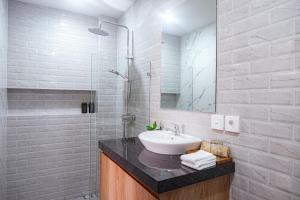 a bathroom with a sink and a glass shower at D'House Seminyak in Seminyak +25 photos