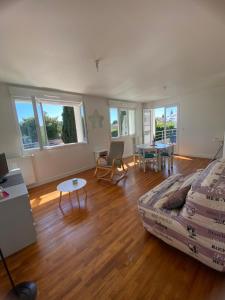 jocelyne في جوانيه - كلان: غرفة معيشة بها أريكة وطاولة