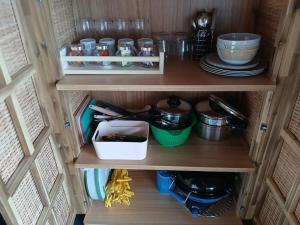 a cupboard with dishes and utensils in it at Safaritent 3 in Biddinghuizen