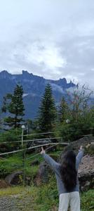 een vrouw die op een heuvel staat en een vlieger laat vliegen bij D'lot 82 Mesilau Kundasang in Kampong Kundassan +15 foto's