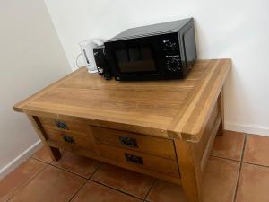 a microwave sitting on top of a wooden table at Double bedroom on the Ormeau Road in Belfast