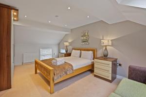 a bedroom with a large bed and a chair at Doray House - North East Escapes in Newton by the Sea