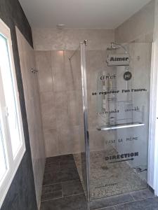 a shower with a glass door in a bathroom at Ecrin des 2 Baies Maison in Vron +10 photos