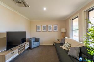 a living room with a couch and a tv at The 4x2 for you and the crew in Williamstown