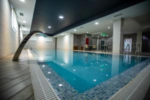 a large swimming pool with a water slide in a building at Volga Hotel Baku in Baku