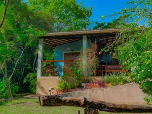 a small house with a bench in the yard at Hospedagem do Sítio in Lençóis