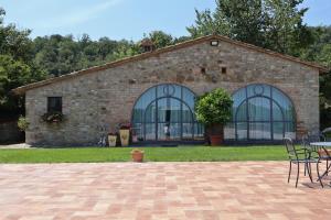 ceglany budynek z oknami oraz stołem i krzesłami w obiekcie Agriturismo Case Corboli villetta Rovello w mieście Todi