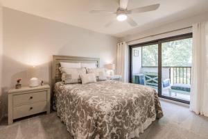 a bedroom with a bed and a sliding glass door at Park Shore Resort Deluxe Condo, water views 232 in Naples +55 photos