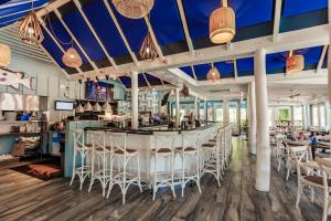a restaurant with white chairs and a bar at Park Shore Resort Deluxe Condo, water views 232 in Naples