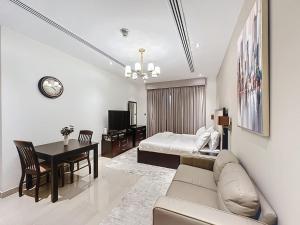 a living room with a couch and a bed and a table at Stunning studio in Downtown Dubai in Dubai