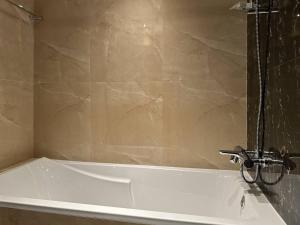 a white bath tub with a faucet in a bathroom at Stunning studio in Downtown Dubai in Dubai +20 photos