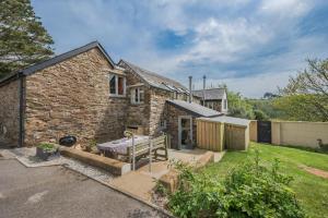 a stone house with a garden in front of it at Little Lanherne Farm Cottage in Saint Mawgan