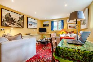 a living room with a laptop on a table at Little Lanherne Farm Cottage in Saint Mawgan