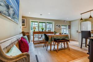 a living room with a table and a kitchen at Little Lanherne Farm Cottage in Saint Mawgan
